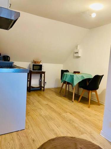 a room with a table and chairs in a room at Studio au cœur des écuries in La Chapelle-Fortin