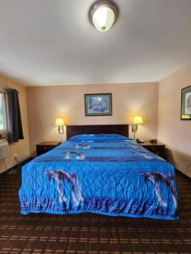 una camera d'albergo con letto e copriletto blu di Mount Laurel Motel a Hazleton