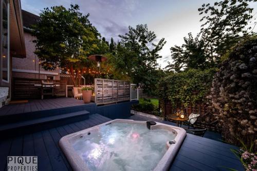 a jacuzzi tub on the deck of a house at Hidden Gem Home-HotTub-Firetable-King Bed-BBQ -Deck in Edmonton
