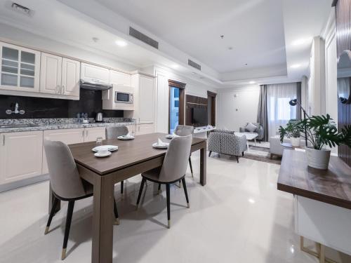 a kitchen and dining room with a table and chairs at Abraj INN Royal Hotel فندق أبراج إن الملكي in Doha