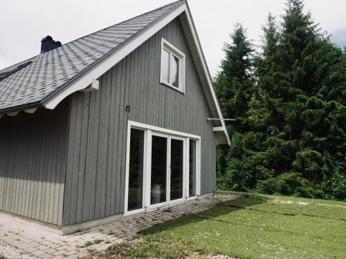 a gray house with a large window at Sportsmen´s Holiday House in Otepää