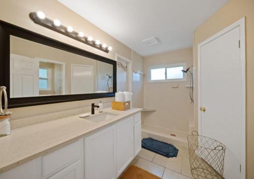 a bathroom with a sink and a mirror at Cozy Brick Home in San Antonio