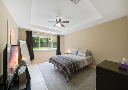 a bedroom with a bed and a ceiling fan at Cozy Brick Home in San Antonio