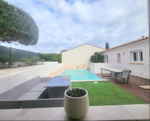 une arrière-cour avec une piscine et une table dans l'établissement villa calme au milieu des vignes avec piscine 2 chambres, à Péret