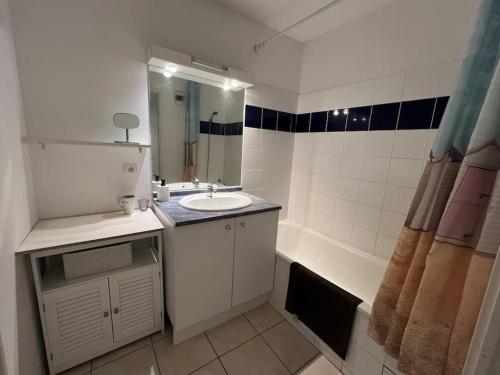 une salle de bain avec un lavabo et une baignoire dans l'établissement Di Castelli T2 avec piscine, à Carcassonne