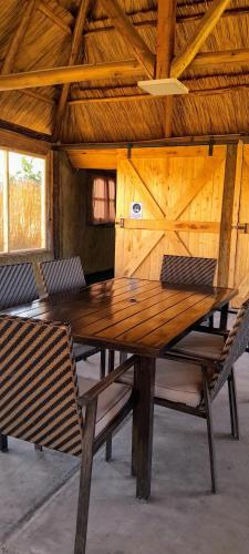 a wooden table and chairs in a room with a wooden ceiling at La Escondida in Tunuyán