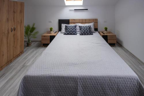 Un dormitorio con una cama grande con dos mesitas de noche. en La Bubu Apartament 2, en Zărneşti