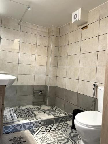 a tiled bathroom with a toilet and a sink at Evanthia's House in Kardamyli