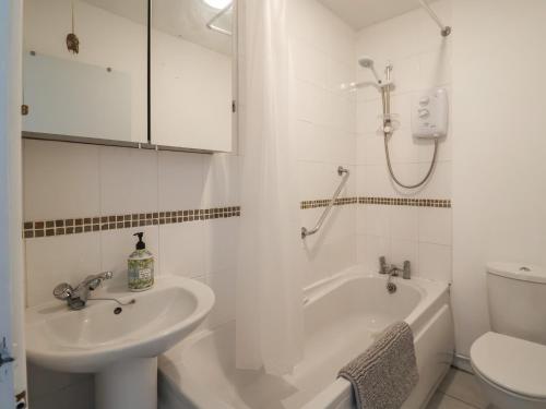 Un baño con lavabo, bañera e inodoro. en 10 Bay View Court, en Lyme Regis