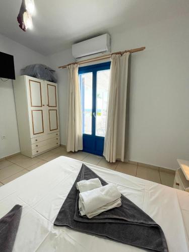a bedroom with a bed with a black blanket on it at Argo-Milos in Adamas