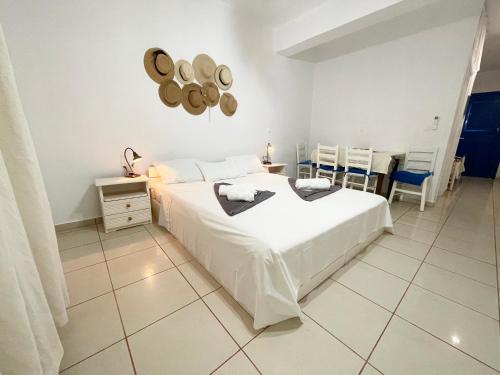 a bedroom with a white bed and a table and chairs at Argo-Milos in Adamas