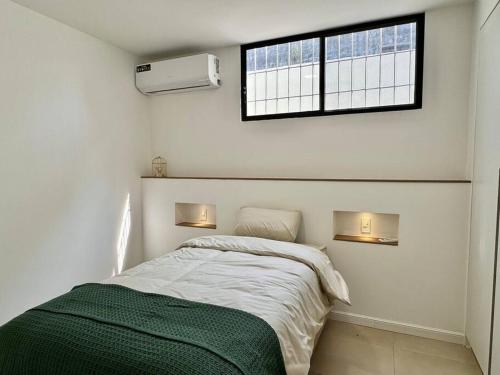 a white bedroom with a bed and a window at Departamento acogedor y moderno in SamborondÃ³n