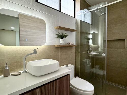 a bathroom with a toilet and a sink and a shower at Departamento acogedor y moderno in SamborondÃ³n