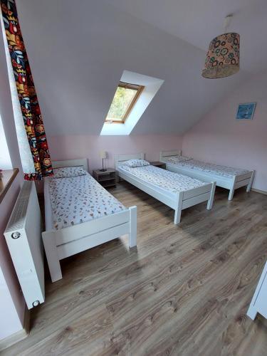 a room with three beds and a window at Domek na Leśnej Wisła in Wisła