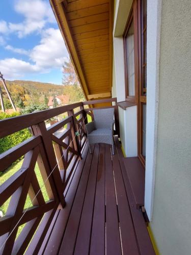 a balcony of a house with a chair on it at Domek na Leśnej Wisła in Wisła