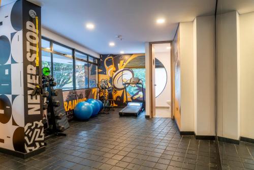 a room with a gym with a wall covered in graffiti at Hotel Living 35 Suites in Medellín