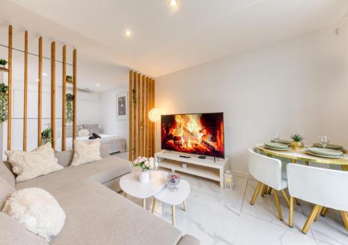 un salon avec un canapé et une cheminée dans l'établissement Évasion Urbaine Studio Cozy avec Terrasse et Parking, à 10 Minutes de Paris Gare du Nord, à Montmagny