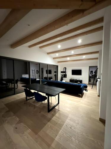 un salon avec une table, des chaises et un canapé dans l'établissement Villa familiale avec piscine chauffée, à Périgny