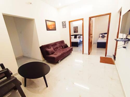 a living room with a couch and a table at Dolphin Luxury villas in Yercaud