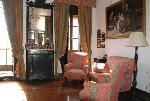 a living room with two chairs and a chair and a lamp at Hotel Ordóñez Sandoval in Úbeda