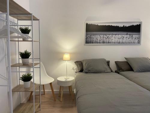a bedroom with a bed and a desk with a lamp at 15 min en metro a Sagrada Familia in Sant Adria de Besos