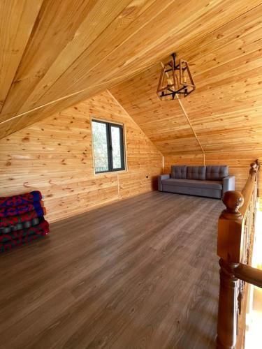 a large room with a couch in a wooden cabin at Jyrgallifе in Darkan