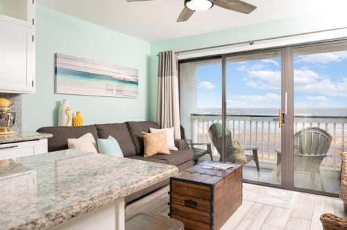 a living room with a couch and a view of the ocean at CDM 351 - Serendipity Sunrise in Galveston