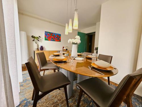 une salle à manger avec une table et des chaises en bois dans l'établissement Charmant T4- Centre Ville- Parking Privé, à Colmar