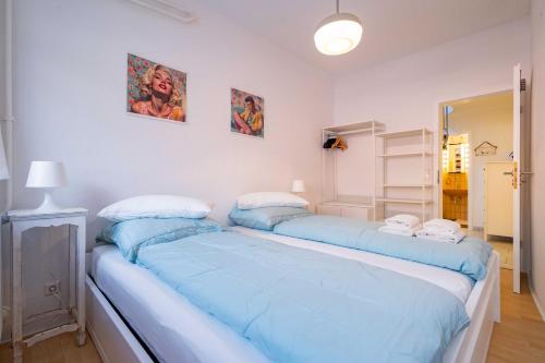 two beds in a room with blue sheets at Charmante Wohnung -Altes Kino- 2SZ-2Bad-Terrasse-Netflix in Baden-Baden
