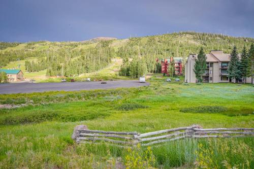 a field of grass with a house and a road at Ski-InandSki-Out Brian Head Condo with Hot Tub! in Brian Head