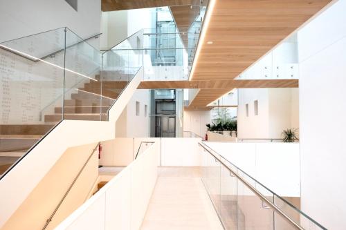 a staircase in a building with white walls and wooden floors at StarPalace Elegance Apartment Jesolo SPA GYM POOL PARKING - a 2 passi dal mare in Lido di Jesolo