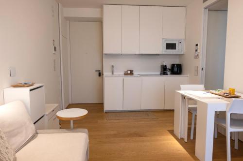 a kitchen with white cabinets and a table in a room at StarPalace Elegance Apartment Jesolo SPA GYM POOL PARKING - a 2 passi dal mare in Lido di Jesolo
