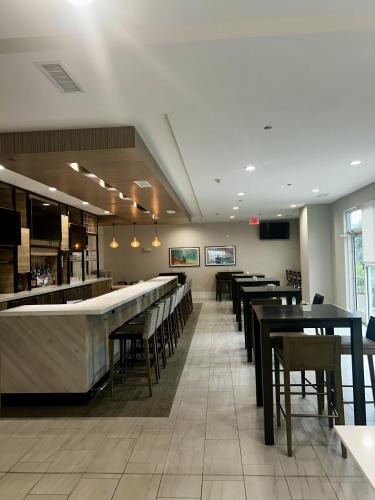 a restaurant with tables and chairs and a bar at Hilton Garden Inn Biloxi in Biloxi