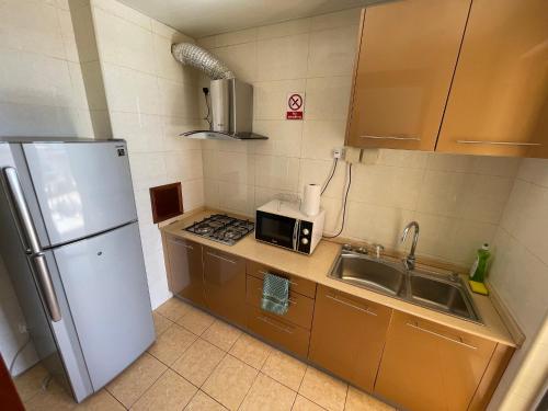 a small kitchen with a sink and a refrigerator at JF Skyline Apartments in Baie du Tombeau