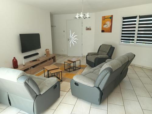 a living room with two couches and a flat screen tv at l'Estran qu'île in LʼÎle-dʼOlonne