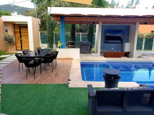 a patio with a table and chairs next to a swimming pool at The Luxury of enjoying Chapala as you deserve B2 in Santa Cruz de la Soledad