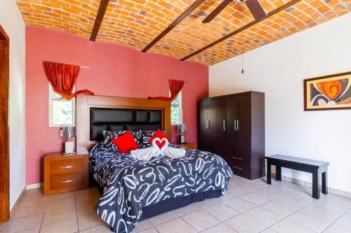 a bedroom with a bed and a red wall at The Luxury of enjoying Chapala as you deserve B2 in Santa Cruz de la Soledad