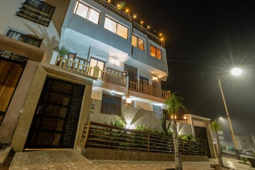 un edificio azul con balcón por la noche en Residence Imsouane Surf Camp, en Imsouane