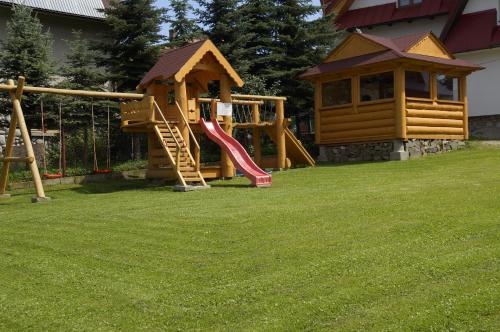 a playground with a slide in a yard at Apartamenty i pokoje Pod Limbami - sauna, tężnia in Bukowina Tatrzańska
