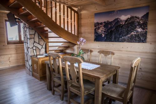 a dining room with a wooden table and chairs at Apartamenty i pokoje Pod Limbami - sauna, tężnia in Bukowina Tatrzańska