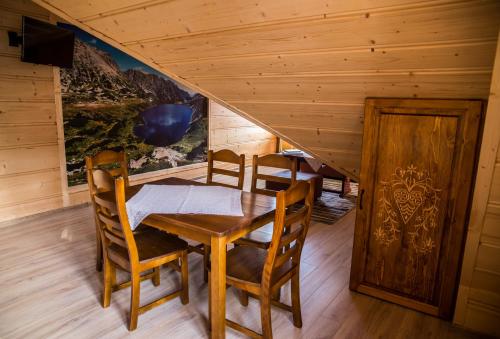 a dining room with a table and chairs at Apartamenty i pokoje Pod Limbami - sauna, tężnia in Bukowina Tatrzańska