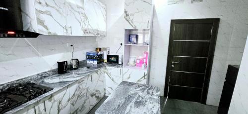 a kitchen with marble counter tops and a black door at Eden Luxurious Apartments in Mosere Ikoga