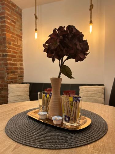 un tavolo con un fiore in un vaso su un vassoio di HAVEN Central Studios a Braşov