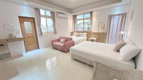 a hotel room with two beds and a pink chair at 過家家民宿GoHouse花蓮市包棟寵物友善 in Hualien City