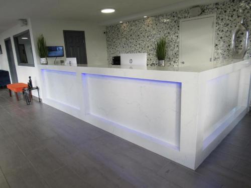 a lobby with a white counter with blue lights at Hotel 10 Extended Stay in New Orleans