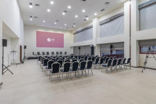 an empty room with chairs and a screen in a building at Exe Convention Plaza Madrid in Madrid