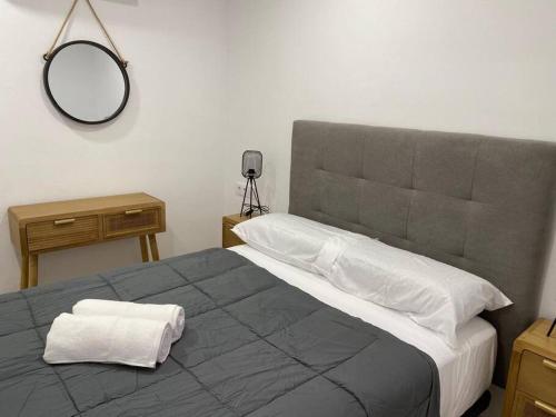 Un dormitorio con una cama grande con un espejo en la pared. en Edifico Mañez Primero- Nuevo, 10 minutos Gibraltar, en La Línea de la Concepción