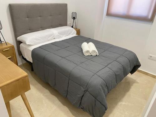 a bed with two white towels on top of it at Edifico Mañez Primero- Nuevo, 10 minutos Gibraltar in La Línea de la Concepción