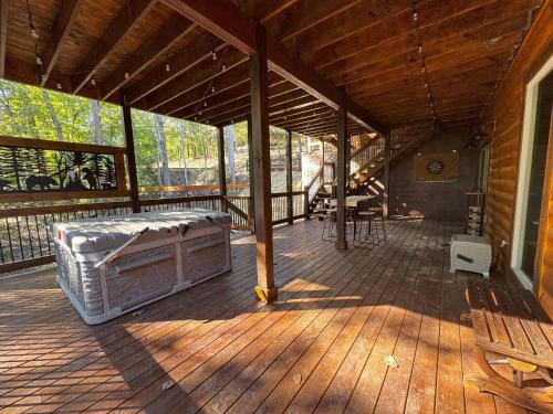 a large wooden porch with a bench on a deck at Lux Cabin Indoor and Outdoor Living in Sevierville