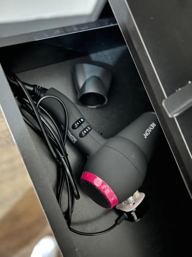 a blow dryer in a drawer of a desk at King Size Studio Apartment Streatham in London